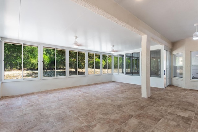 unfurnished sunroom featuring ceiling fan