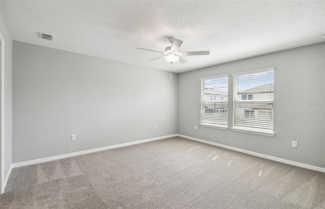 carpeted spare room with ceiling fan and a textured ceiling