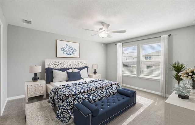 carpeted bedroom with a textured ceiling and ceiling fan