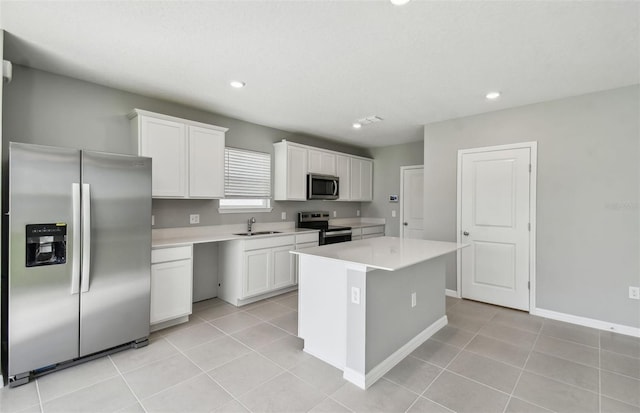 kitchen with a center island, sink, white cabinets, and stainless steel appliances