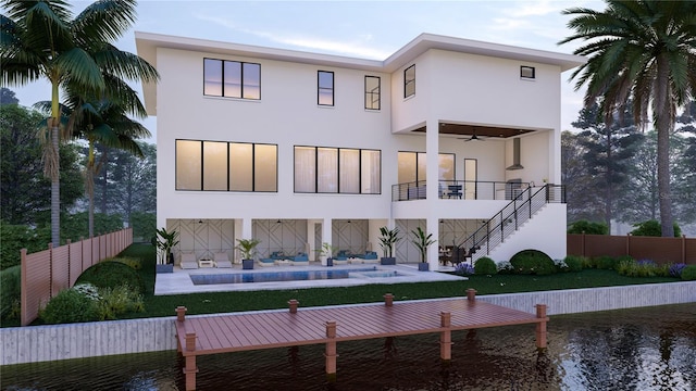 back of house with ceiling fan and a fenced in pool