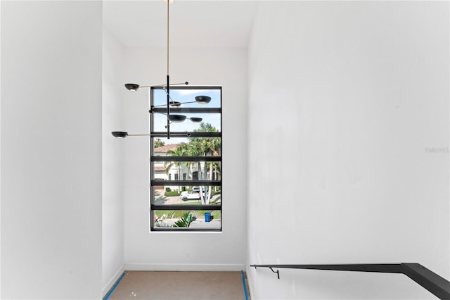 staircase featuring baseboards and concrete flooring