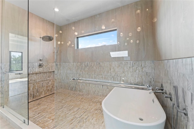 full bathroom with a sink, tile walls, a freestanding tub, and walk in shower