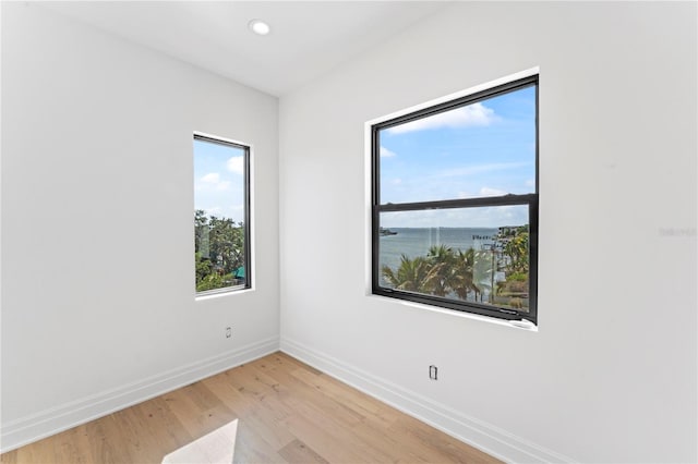 spare room featuring recessed lighting, baseboards, and light wood-type flooring