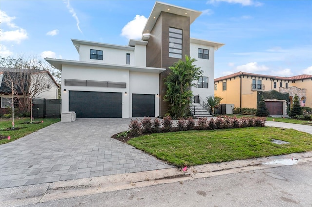 view of front of property featuring stucco siding, an attached garage, decorative driveway, and a front lawn