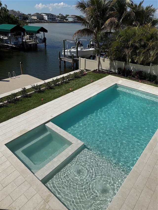 view of pool featuring fence, a boat dock, a pool with connected hot tub, a water view, and boat lift