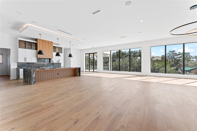 unfurnished living room with light wood-type flooring, visible vents, and recessed lighting