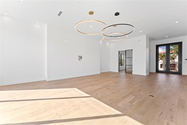 unfurnished room with a chandelier, recessed lighting, baseboards, and wood finished floors