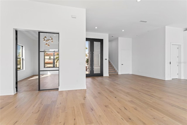 interior space featuring recessed lighting, baseboards, stairs, and light wood-style floors