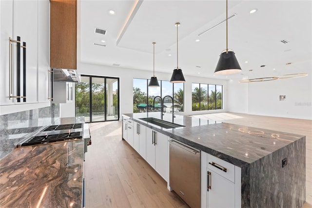 kitchen featuring visible vents, dark stone counters, a sink, appliances with stainless steel finishes, and white cabinetry