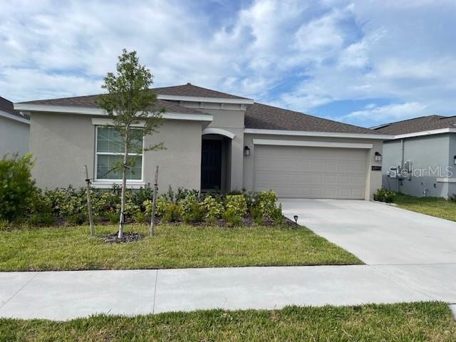 single story home featuring a front lawn and a garage