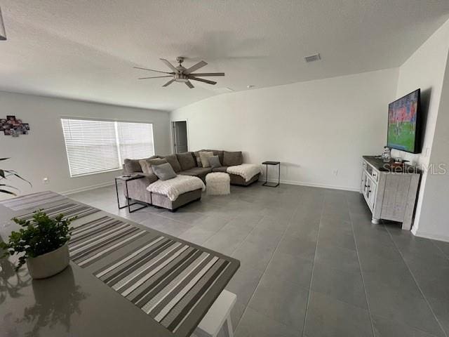 living room featuring ceiling fan and lofted ceiling