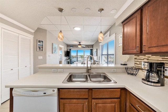 kitchen with kitchen peninsula, tasteful backsplash, ceiling fan, white dishwasher, and sink