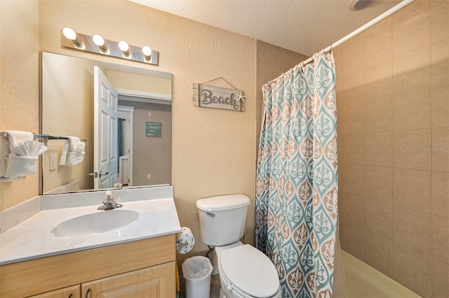 bathroom featuring a textured ceiling, vanity, and toilet