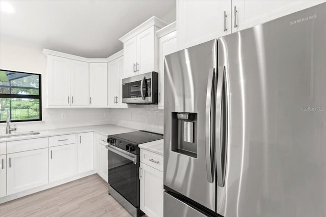 kitchen featuring white cabinets, decorative backsplash, sink, and stainless steel appliances