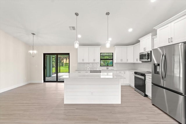 kitchen with a kitchen island, pendant lighting, decorative backsplash, white cabinetry, and appliances with stainless steel finishes