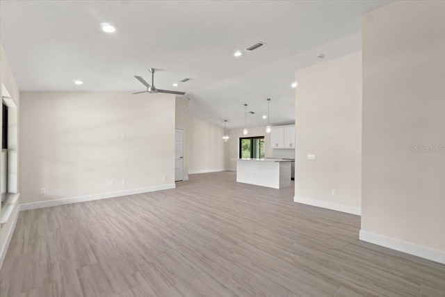 unfurnished living room featuring lofted ceiling, ceiling fan, and hardwood / wood-style floors