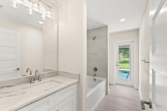 bathroom featuring vanity, tiled shower / bath, and hardwood / wood-style flooring