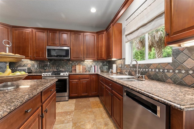 kitchen with stone countertops, stainless steel appliances, tasteful backsplash, and sink