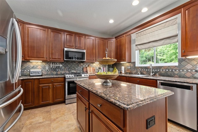 kitchen with a center island, sink, decorative backsplash, dark stone countertops, and stainless steel appliances