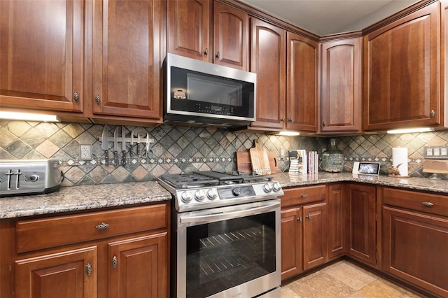 kitchen with dark stone counters, decorative backsplash, and stainless steel appliances