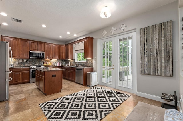 kitchen with a center island, french doors, sink, tasteful backsplash, and stainless steel appliances