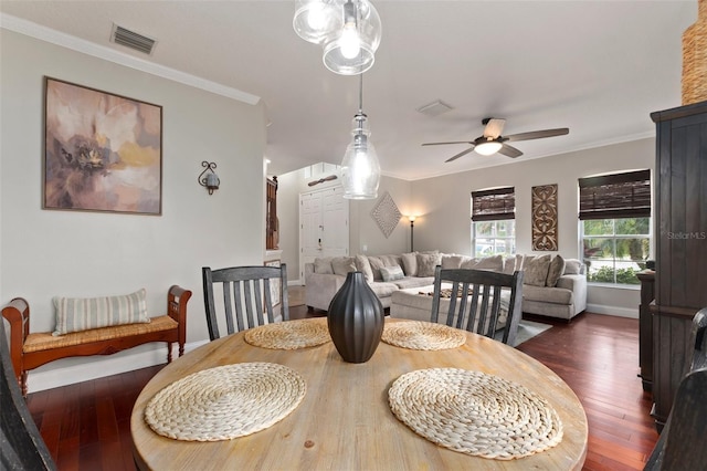 dining space with ceiling fan, dark wood-type flooring, and ornamental molding