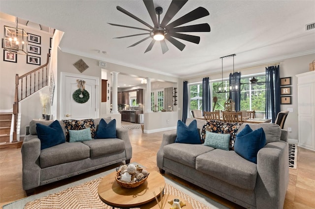 living room featuring decorative columns, crown molding, a textured ceiling, and ceiling fan with notable chandelier