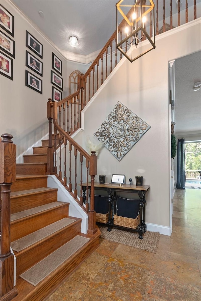 stairs featuring crown molding and a chandelier