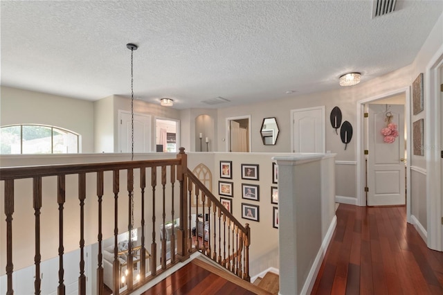 hallway with dark wood-type flooring and a textured ceiling