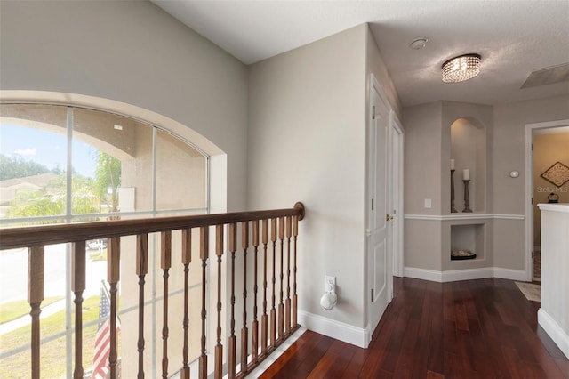 hall with dark hardwood / wood-style flooring and a textured ceiling