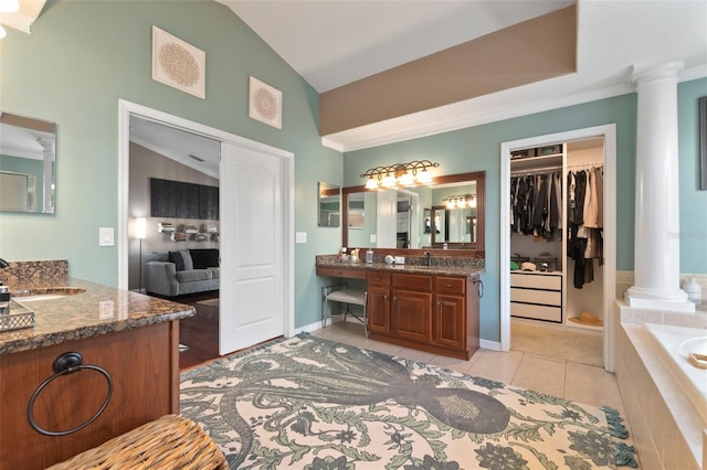 bathroom with decorative columns, vanity, vaulted ceiling, and ornamental molding