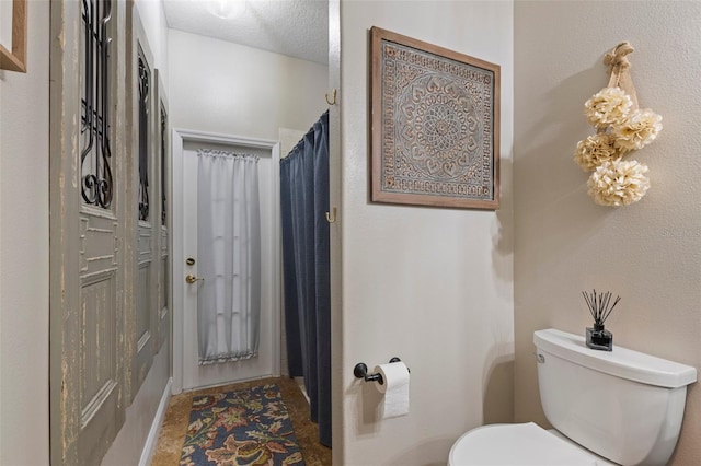 bathroom with a textured ceiling and toilet