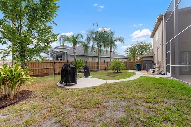 view of yard featuring glass enclosure and a patio area