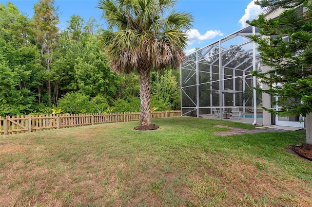 view of yard featuring glass enclosure and a fenced in pool