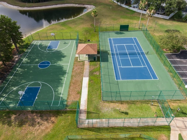 view of basketball court featuring tennis court and a water view