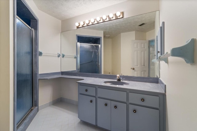 bathroom featuring vanity, a textured ceiling, and an enclosed shower