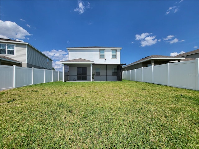 back of property featuring a yard, a fenced backyard, and a sunroom