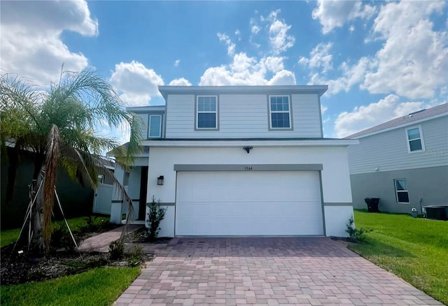 traditional-style home featuring central AC, a front yard, stucco siding, decorative driveway, and a garage