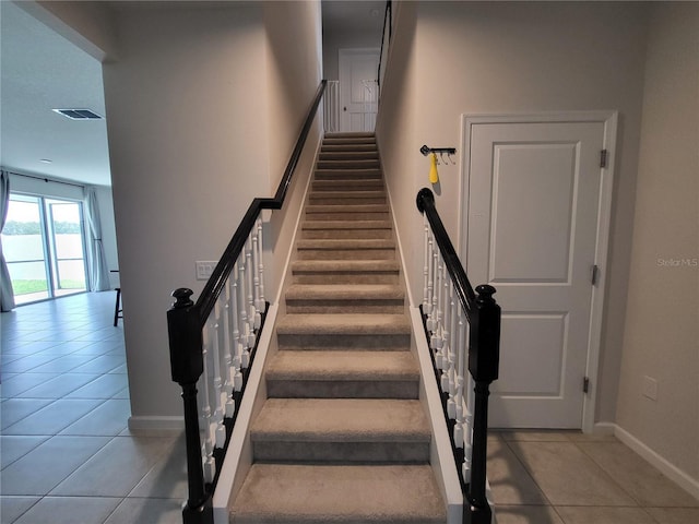 stairway featuring tile patterned flooring, baseboards, and visible vents