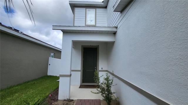 property entrance with stucco siding