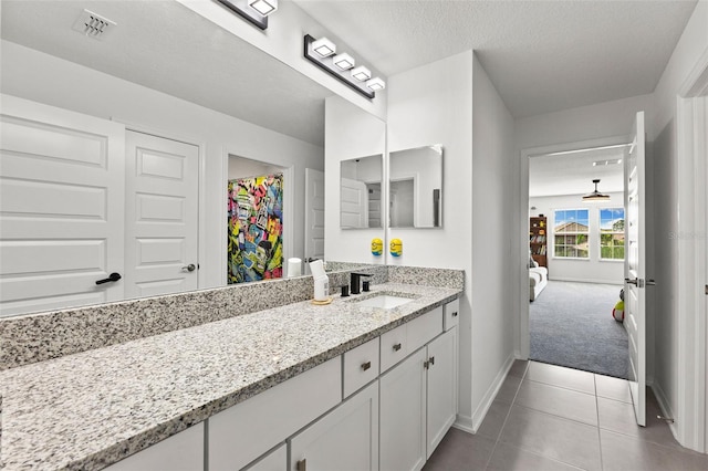 bathroom featuring a textured ceiling, tile patterned floors, and vanity