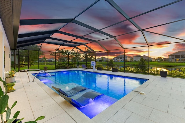 pool at dusk featuring a patio area, glass enclosure, and a water view