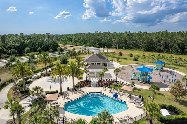 view of pool featuring a playground and a patio