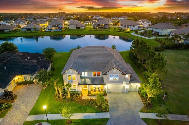 aerial view at dusk featuring a water view