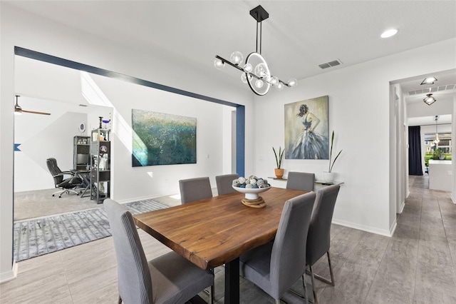 dining area featuring ceiling fan with notable chandelier and light hardwood / wood-style floors