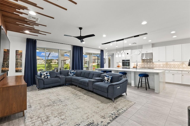 tiled living room with ceiling fan and sink