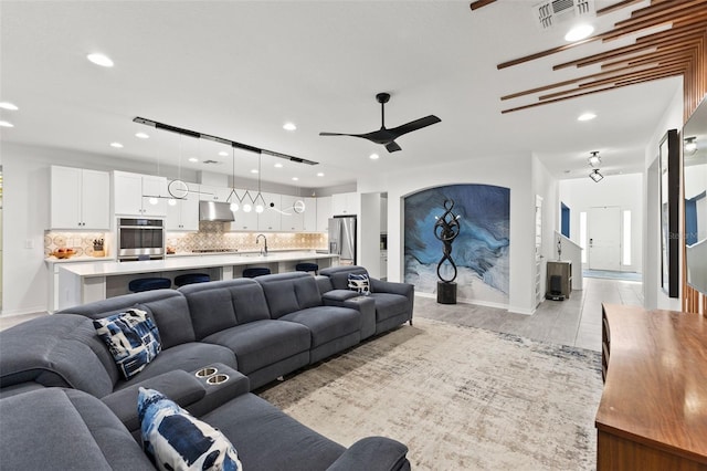 living room featuring ceiling fan and sink