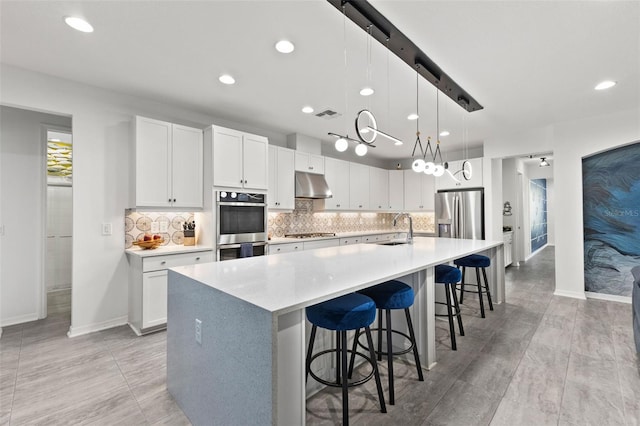 kitchen with sink, white cabinets, a spacious island, and appliances with stainless steel finishes