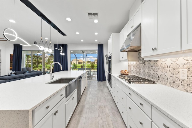 kitchen with appliances with stainless steel finishes, decorative backsplash, white cabinets, and sink